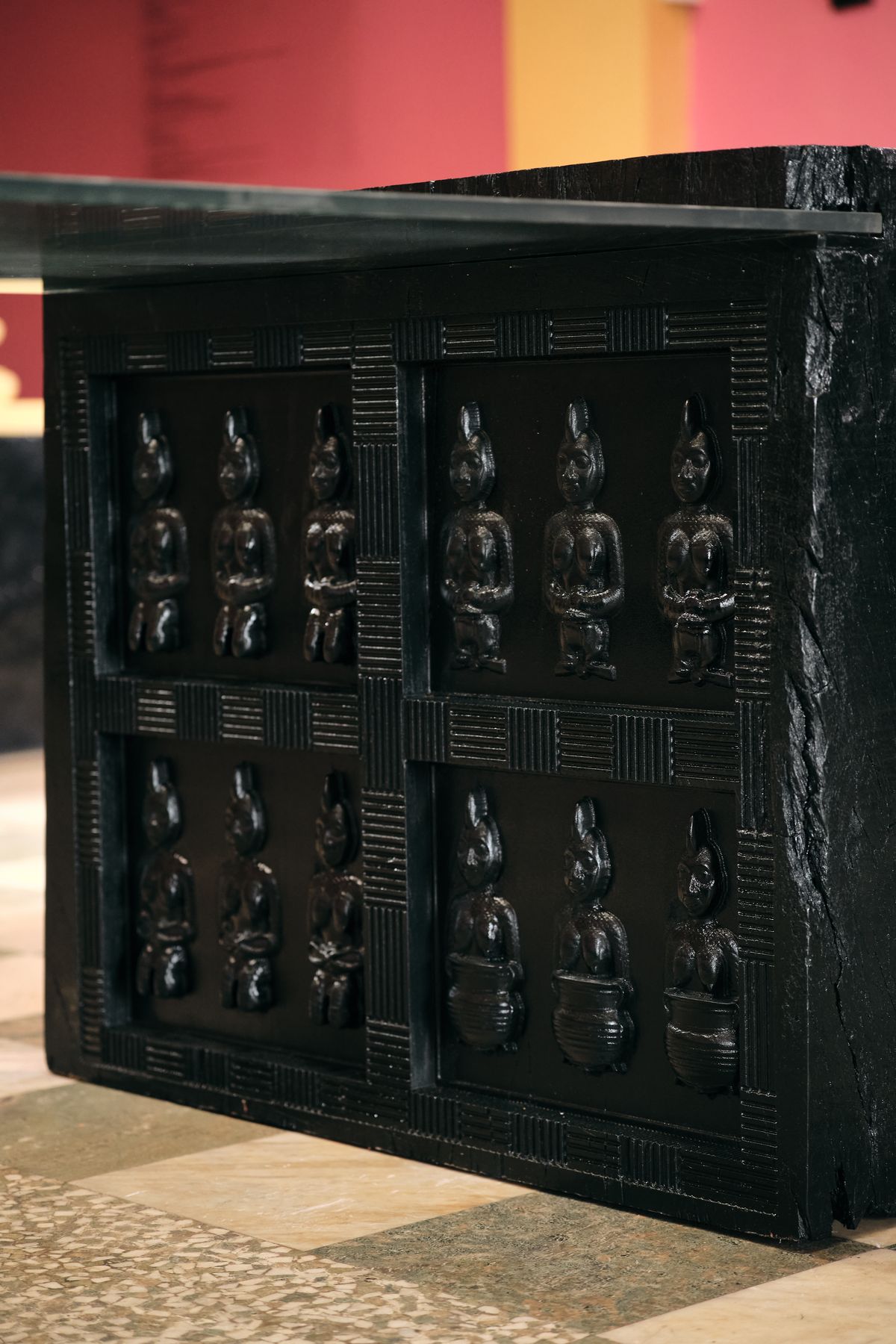 The end panel, carved in relief with twelve figures; the lower row stand with pots